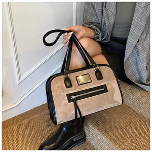 Vue détaillée du sac vintage en daim beige et cuir noir avec finitions métalliques dorées