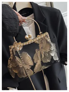 Gros plan du sac vintage en brocart noir avec broderies dorées et fermoir en perles