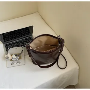 Vue intérieure du sac cabas en cuir marron foncé montrant sa grande capacité et ses poches