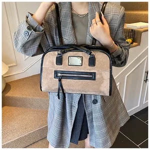 Vue détaillée du sac cabas en daim kaki avec bordure noire, métal et pompon à franges