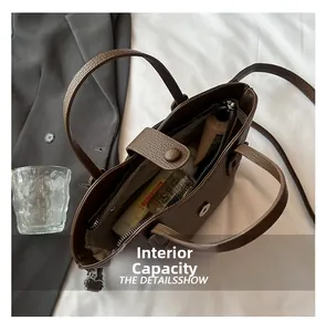 Vue de dessus de la capacité interne du sac à main marron à motif litchi avec objets