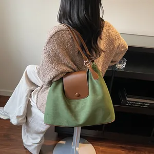 Macro shot of green canvas and brown leather straps on large capacity tote bag