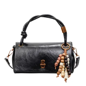 Vintage black faux leather handbag with amber-style beads and knot handle detail