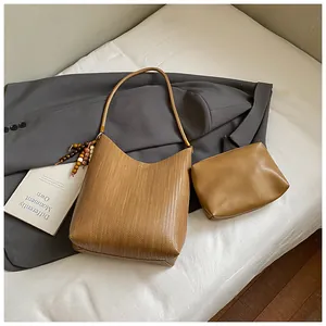 Détail du lot de sacs à main marron tressé avec pompons décoratifs en perles