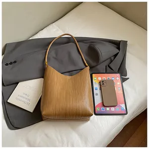 Sac hobo marron moka à texture tissée, stylisé avec un blazer gris et des appareils