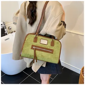 Détails du sac cabas en daim vert vintage avec bordures en cuir marron et pompons