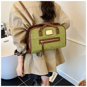 Détail du sac cabas en daim vert olive avec logo en métal doré et poche à fermeture frangée