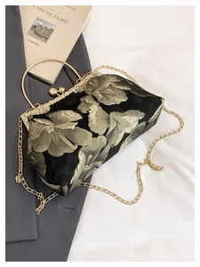 Détail du sac de soirée brodé avec poignée en anneau doré et fermoir perle