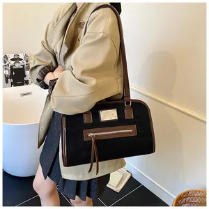 Détail d'un sac cabas rétro noir avec garniture en cuir marron et plaque en métal