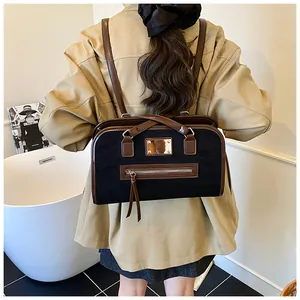 Vue de dos du mannequin portant un sac fourre-tout en daim noir et cuir marron chic