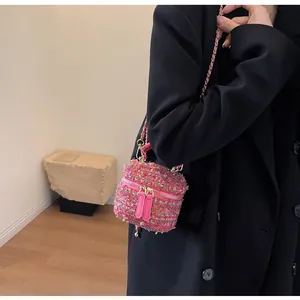 Mini-Box-Tasche aus rosa Tweed mit goldener Kette am Modell für Größenperspektive
