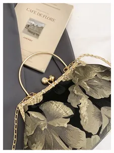 Détail d'une pochette brodée vintage avec fermoir perle, cadre cristal et anse dorée
