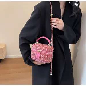 Rosa Tweed-Beuteltasche mit Goldkette, getragen zum schwarzen Anzug