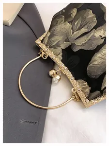 Détail de broderie florale sur sac de soirée vintage avec cadre en strass et perles
