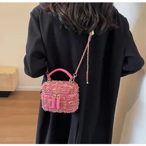 Modell mit rosa Tweed-Kosmetiktasche und Kettenriemen über schwarzem Mantel Rückansicht