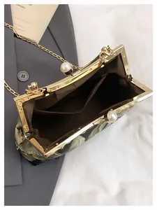 Détail de l'intérieur du sac floral vintage avec fermoir perle et bandoulière dorée