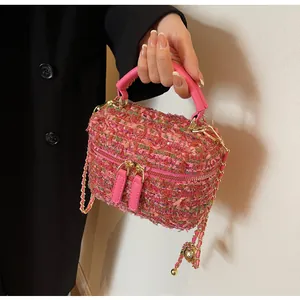 Detail der Tweed-Eimertasche in Rosa mit bunter Textur und goldener Kettenriemen