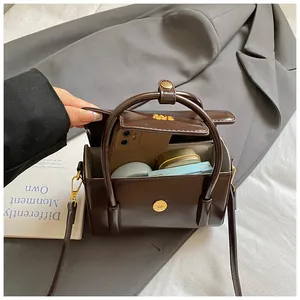 Detail view of brown PU leather bag interior with herringbone lining and essentials