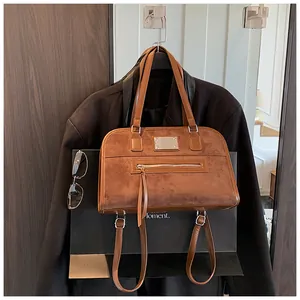 Détail d'un grand cabas vintage marron mat avec doubles poignées et poche zippée en métal