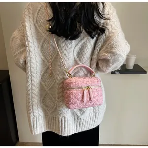 Mini sac bandoulière en tweed rose porté par un mannequin dans un décor élégant
