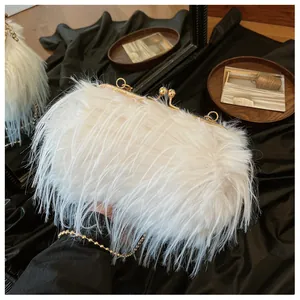 Detailed view of white ostrich feather evening bag with pearl clasp and gold chain strap