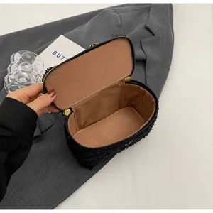 Detailed view of black tweed bag interior with textured lining and golden zipper