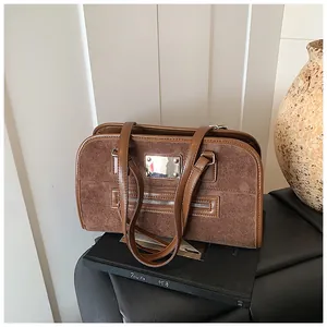Gros plan d'un sac cabas en daim marron avec garniture en cuir et boucle métal