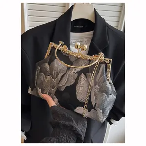 Sac à main brodé floral noir élégant avec fermoir perle dorée et bandoulière chaîne