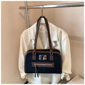 Détail du sac fourre-tout rétro en tissu mat noir avec des lanières en cuir marron