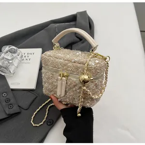 Detail der Tweed-Eimertasche mit goldener Kette und metallischem Kugelversteller