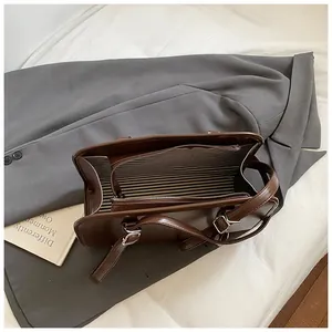 Vue de dessus d'un sac cabas marron montrant la doublure rayée et les zips