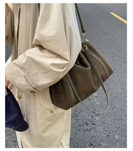 Dettaglio borsa Boston vintage in pelle scamosciata marrone con manici in pelle verde