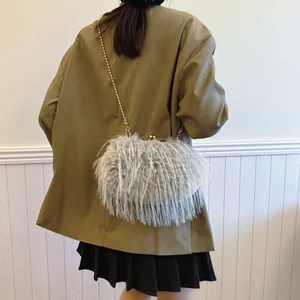 Chic gray faux fur crossbody bag with gold chain strap shown on model in interior setting