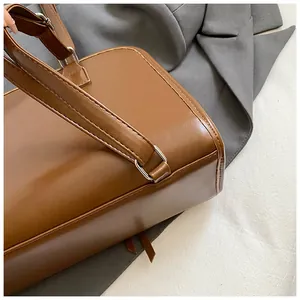 Détail d'un sac cabas en cuir marron avec boucle en métal argenté et coutures renforcées