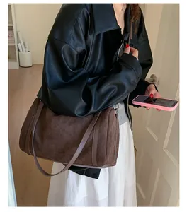 Borsa tote in pelle scamosciata marrone sulla spalla in un contesto lifestyle per riferimento