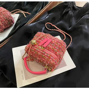 Detail der Tweed-Umhängetasche mit verstellbarer Goldkette und pinkfarbenem Ledergriff