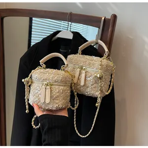 Detailaufnahme der Tweed-Tasche mit Pailletten, Goldkette und Doppelreißverschluss