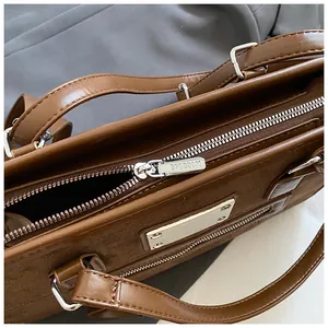 Détail de la fermeture éclair en métal et du cuir texturé de ce sac cabas marron