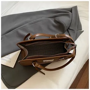 Vue de dessus du sac cabas en cuir marron avec doublure rayée et fermeture éclair