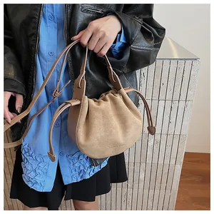 Detail der gerafften Wildleder-Cloud-Tasche mit Kordelzug und glattem Leder-Trageriemen