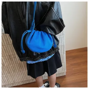 Blaue Plissee-Umhängetasche aus Wildleder mit Kordelzug und geprägtem Logo am Taschenboden