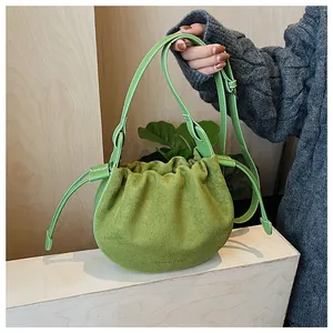 Detail der grünen Wildleder-Beuteltasche mit Lederbesatz und verstellbarem Schultergurt