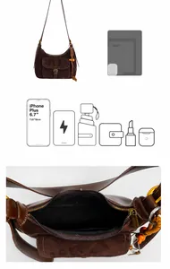 Macro view of dark brown suede shoulder bag with interior pocket and zipper closure
