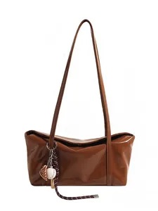 Brown faux leather underarm bag with glossy finish and baseball themed keychain