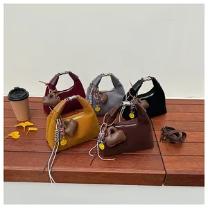 Chic suede bucket bags in five autumn colors displayed on a bench with autumn decor