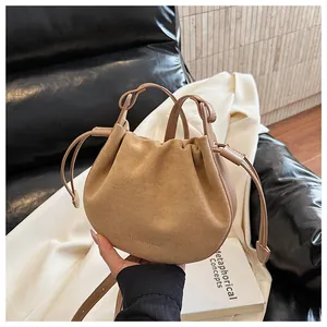 Makroansicht der camel-farbenen Veloursleder-Tasche mit Kordelzug und Ledergriff