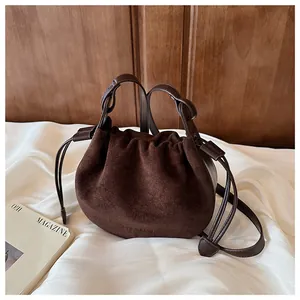 Detailaufnahme der dunkelbraunen Wildleder-Beuteltasche mit eleganter Faltenstruktur