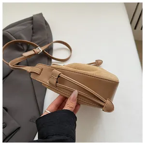 Detail der braunen Schultertasche mit Falten, Seitennaht und verstellbarer Schnalle