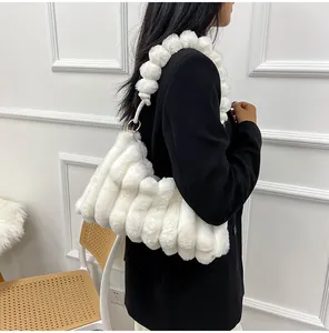 Détail du sac bandoulière en fausse fourrure blanche avec texture et sangle pompon