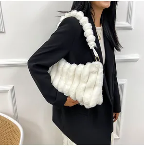 Détail du sac à bandoulière en fausse fourrure blanche avec texture plissée et anneaux dorés
